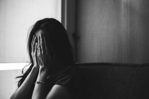 Een vrouw verbergt haar gezicht achter haar handen
