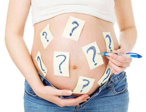 De buik van een zwanger vrouw beplakt met vraagtekens