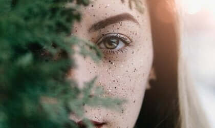 Een gezicht dat schuilt achter een boom