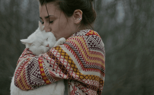 Een vrouw knuffelt een kat