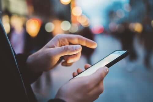 Een man typt op zijn mobiele telefoon