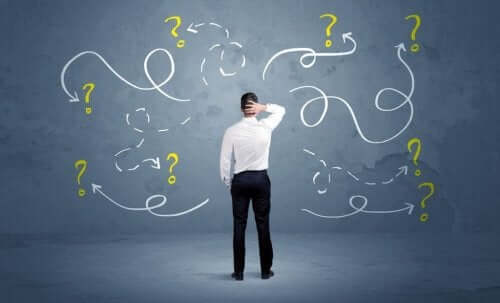 Een man staat voor een schoolbord met vraagtekens