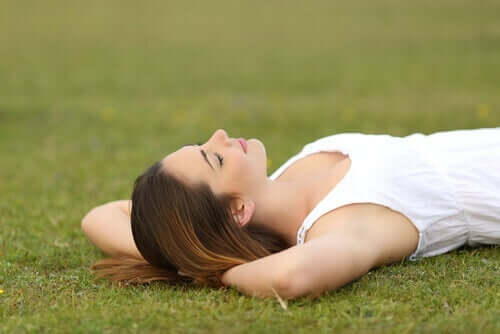 Een vrouw ligt ontspannen in het gras