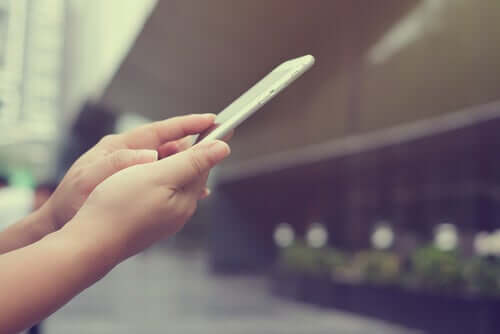 Een vrouw kijkt naar haar mobiele telefoon