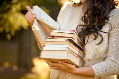 Een vrouw met een stapel boeken