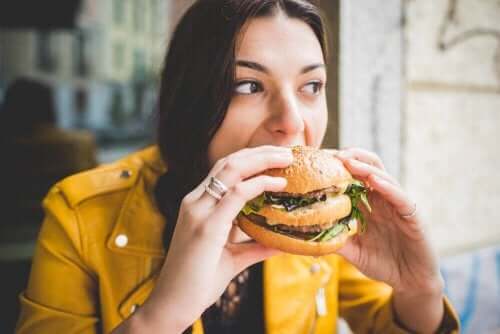 Een vrouw eet een hamburger