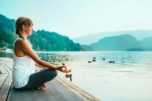 Een vrouw mediteert aan een meer