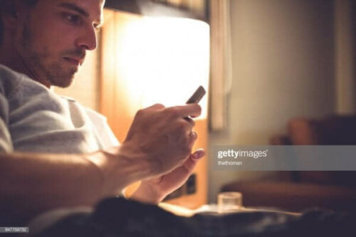 Een man kijkt op zijn mobiele telefoon