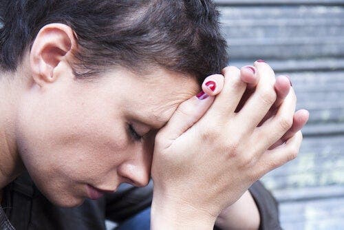 Een vrouw houdt haar handen tegen haar voorhoofd