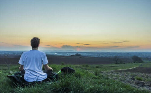 Een man mediteert in de buitenlucht