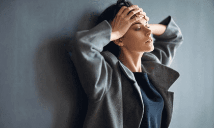 Een vrouw leunt tegen de muur