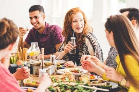 Een groep mensen zit aan tafel te eten en te praten