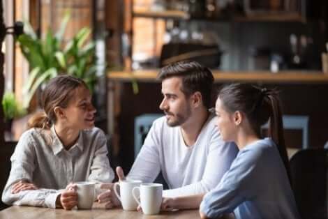 Drie mensen met elkaar in gesprek in een café