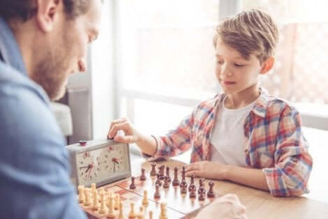 Een jongetje schaakt met zijn vader