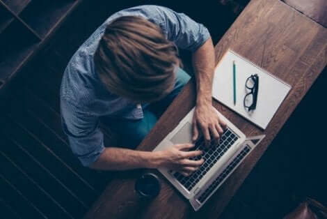 Een man typt op zijn laptop