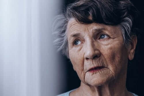Een oudere vrouw staat naast het raam
