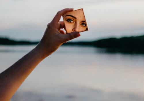 Het gezicht van een vrouw in een kleine make-upspiegel