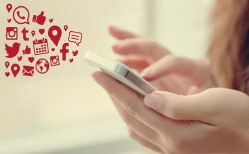 Een mobiele telefoon met de logo's van verschillende sociale media platvormen erbij