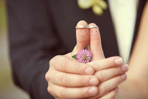 Een koppel showt trouwringen op hun duimen met hun handen tegen elkaar