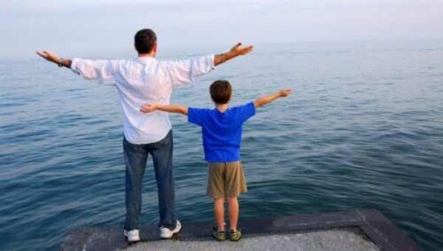 Een vader met een zoon spreiden allebei hun armen