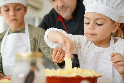 Kinderen met schorten en een koksmuts zijn aan het koken