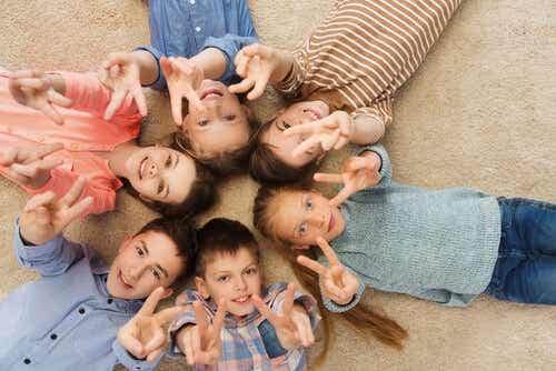 Een groep kinderen maakt het vredesteken met hun vingers