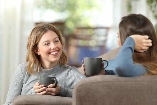 Twee vrouwen praten met een kop koffie in hun handen