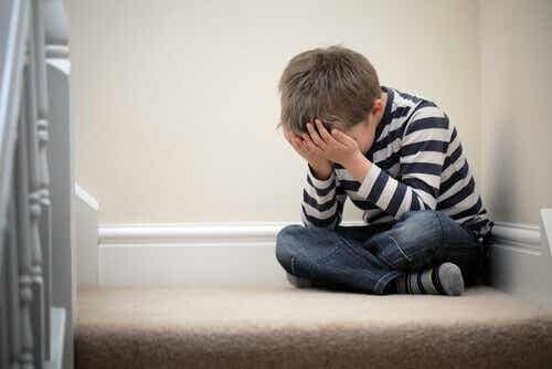 Een kind zit huilend op de trap