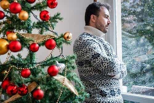Een man staat boos bij een kerstboom