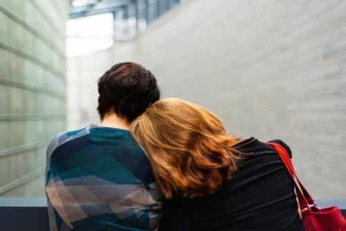 Een vrouw met haar hoofd op de schouder van een man