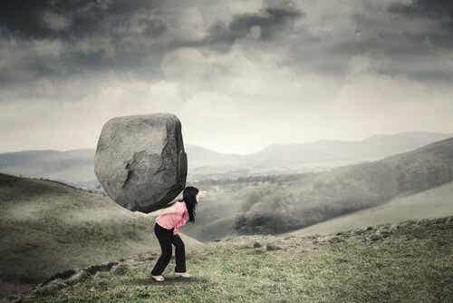Een vrouw die een grote steen draagt