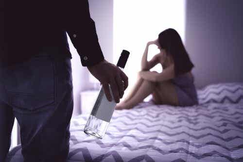 Een man met een fles die naar een vrouw kijkt