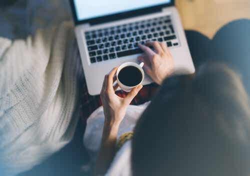 Een vrouw drinkt koffie en werkt op haar computer