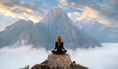 Vrouw mediteert op een berg